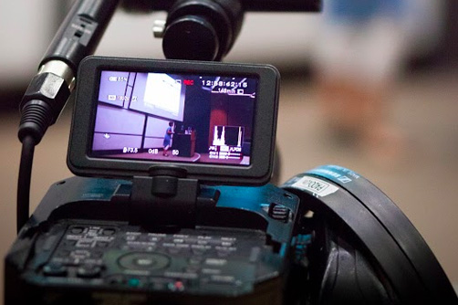 Lecturer viewed behind a camera monitor