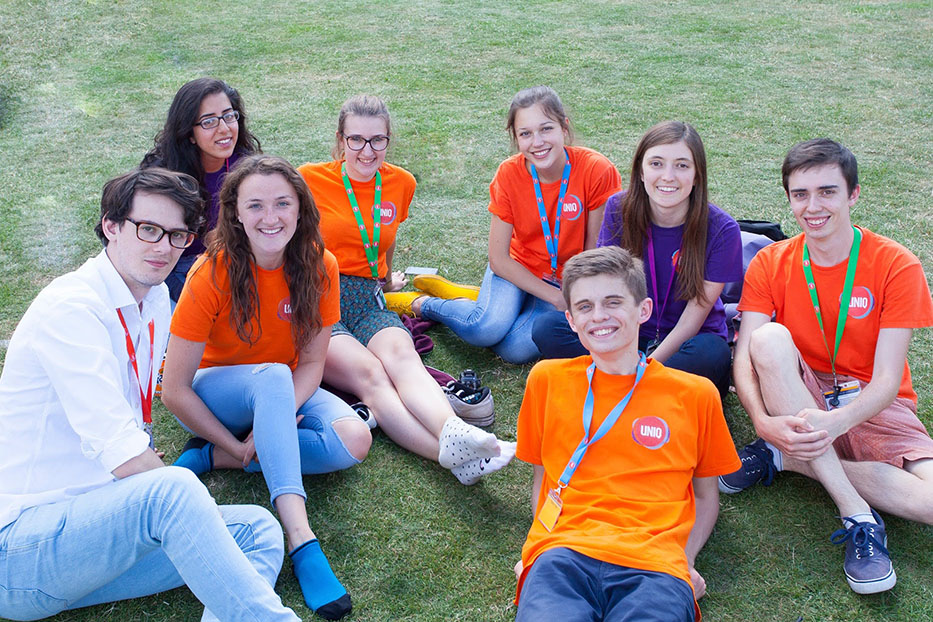 A group of student staff sitting in a field