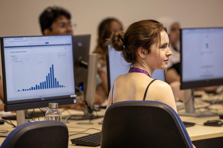 Student in front of computer with graph displayed on it